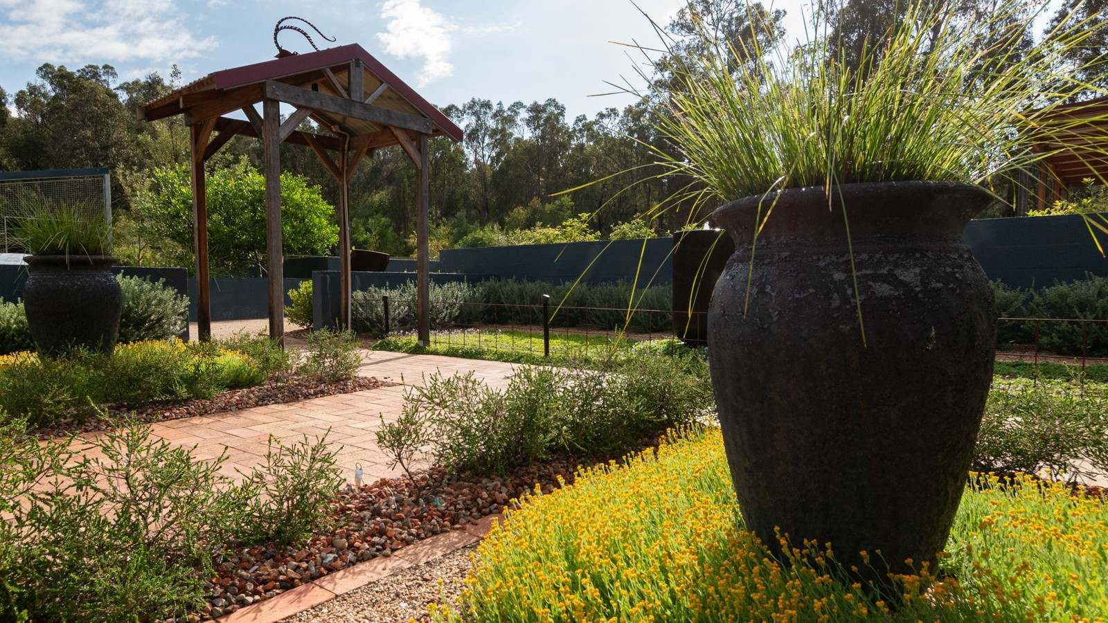 Naturescape garden with plant pot and small gazebo structure banner image