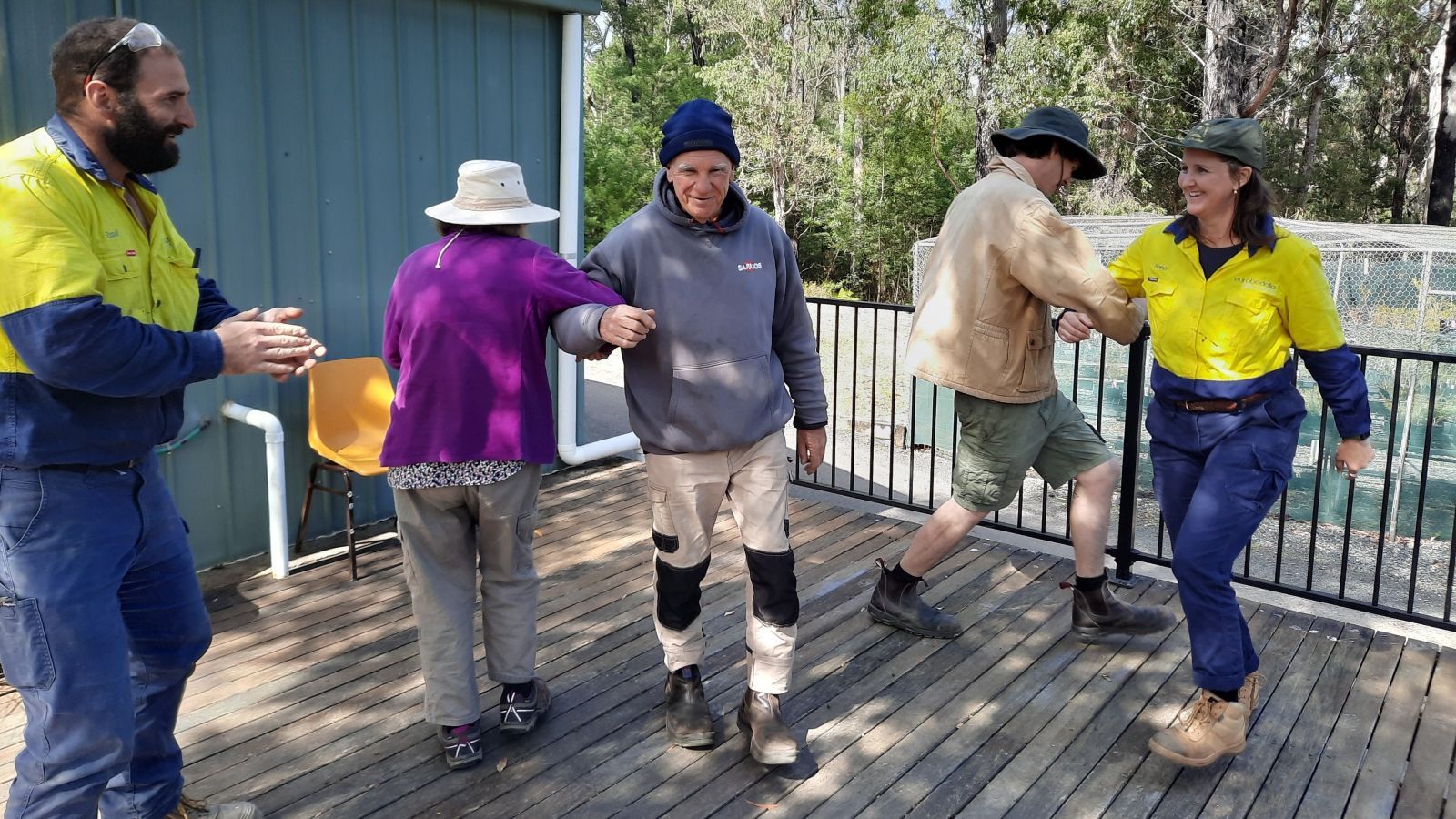 Five people dancing on an outdoor deck. banner image