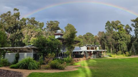Image of the Garden visitor centre with a rainbow over the building